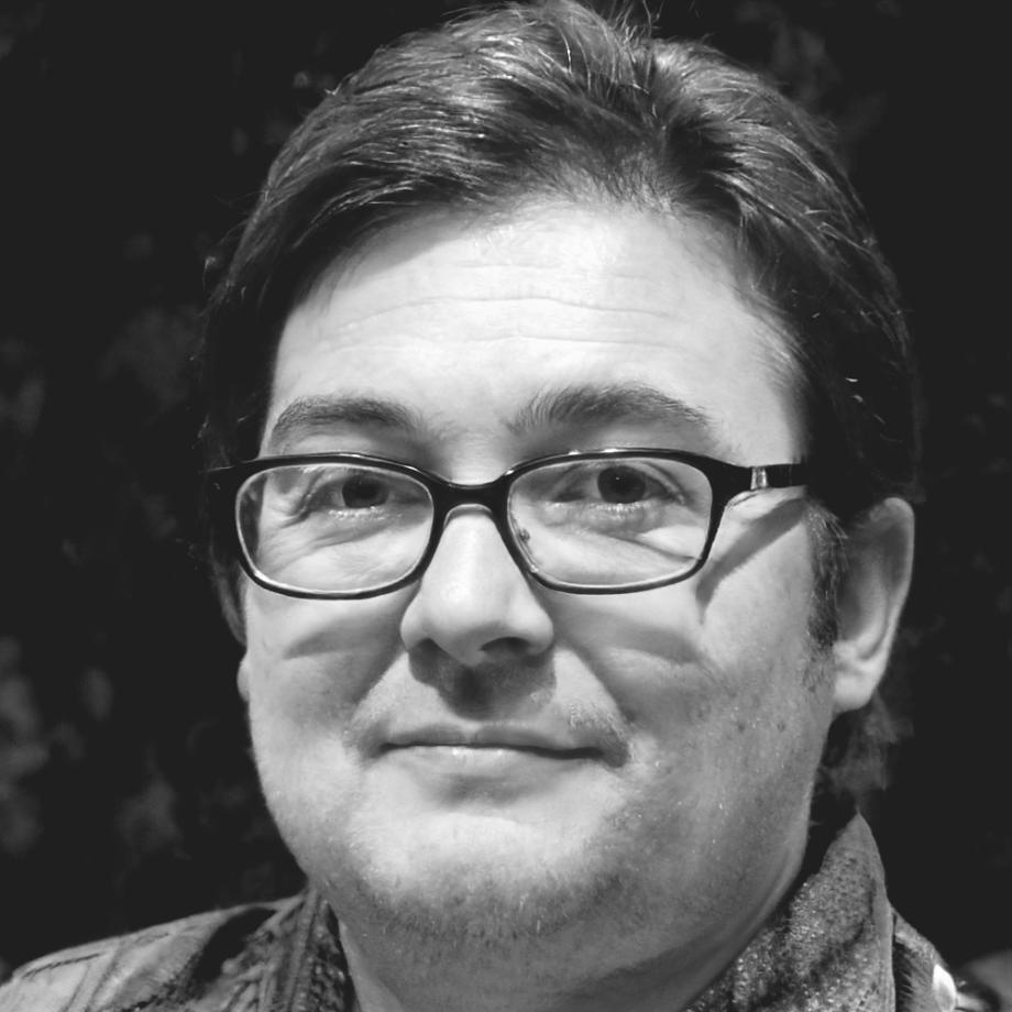 Tamsin Wycliffe analyzing financial data at his workspace